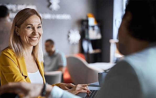 Business-Frau lacht freundliche und schüttelt einem Mann die Hand