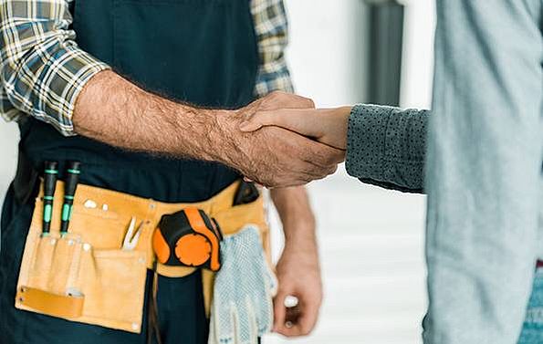 Handwerker gibt Kundin die Hand