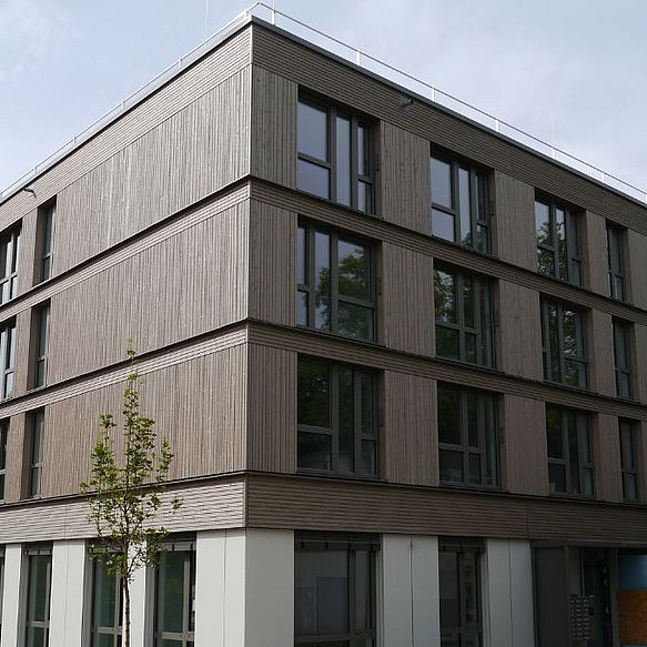 Modernes, dreistöckiges Gebäude mit dezentem Fassadenabschluss in der Fensterlaibung