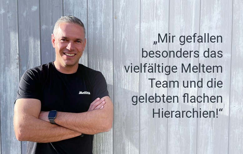 Ein Mitarbeiter vor einer blauen Holzwand