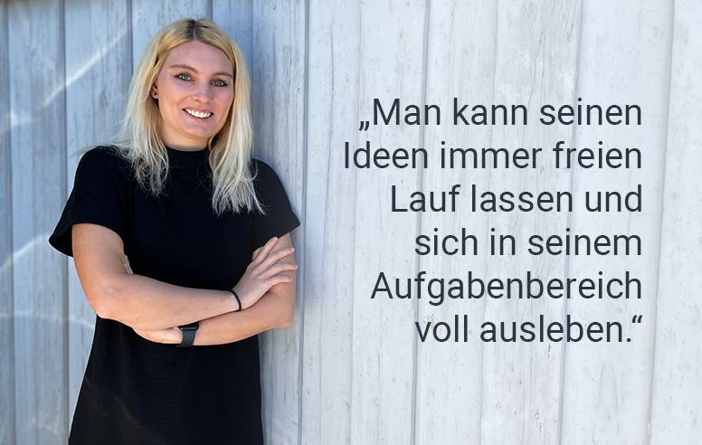 Ein Mitarbeiter vor einer blauen Holzwand