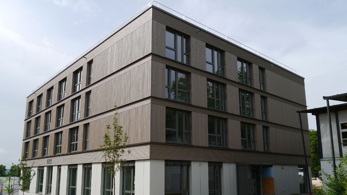 Modernes, dreistöckiges Gebäude mit dezentem Fassadenabschluss in der Fensterlaibung